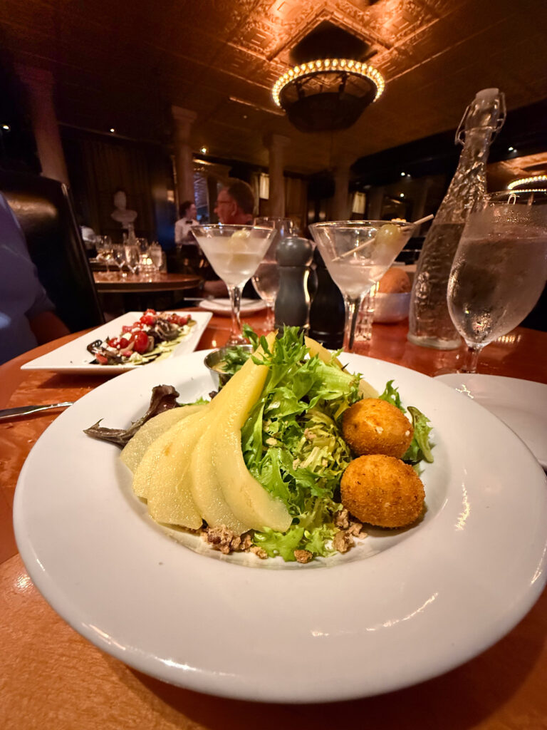 Poached pear salad and cocktails at Garibaldi's Café in Savannah, Georgia, one of our favorite date night restaurants in the Historic District.