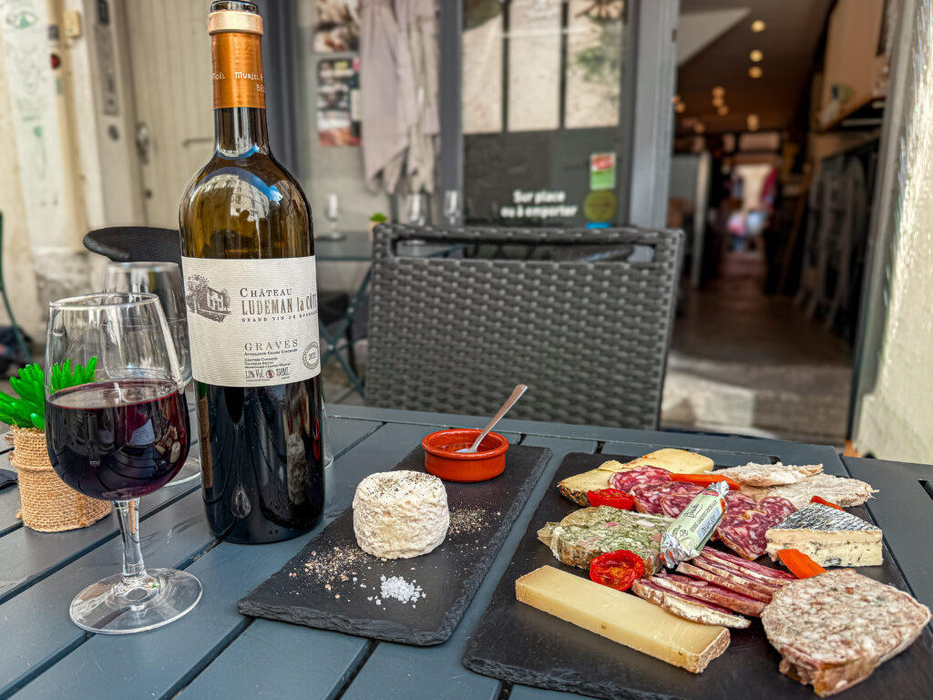 French wine, cheese, and charcuterie board served at an outdoor café during a leisurely lunch in France.